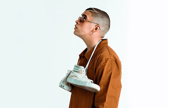 Bad Bunny Aesthetic With Hanging Shoes On Neck Looking Up Wearing Brown Coat In White Background Music, HD wallpaper