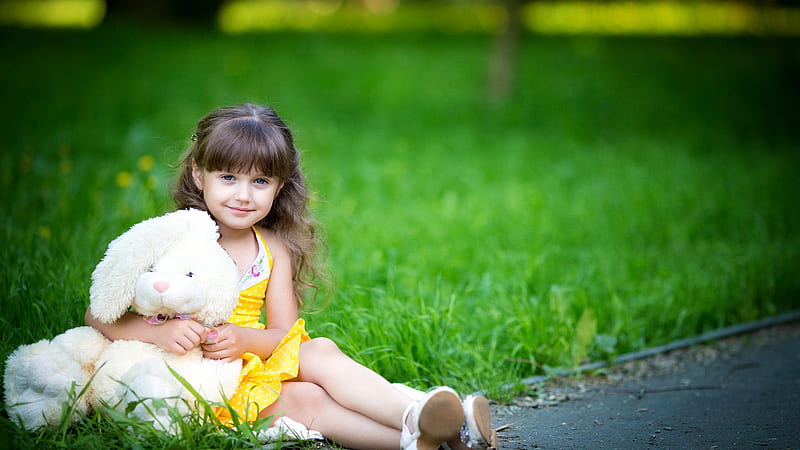 Cute Little Girl Is Wearing Yellow Dress Sitting On Green Grass In Blur Green Background With Teddy Toy Cute, HD wallpaper