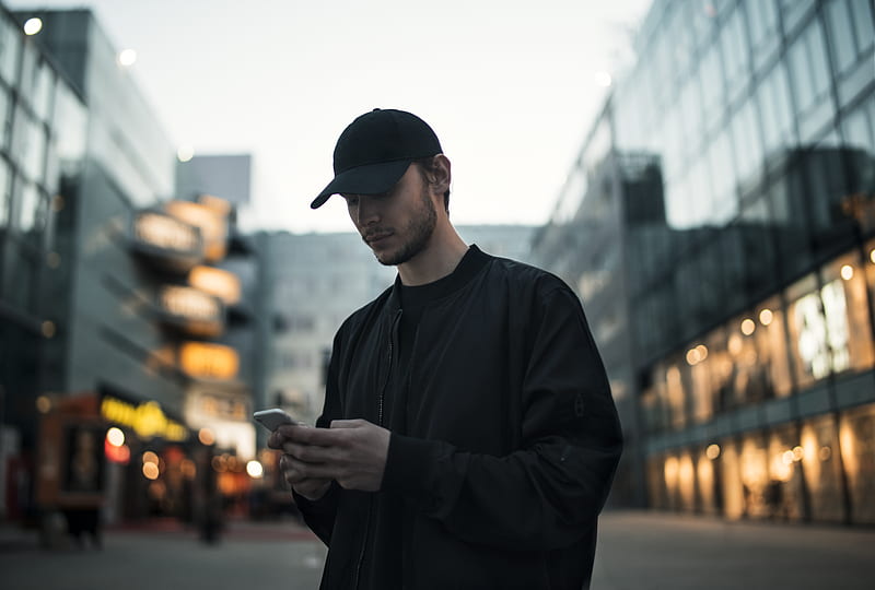 man in black jacket wearing black fitted cap while using phone, HD wallpaper