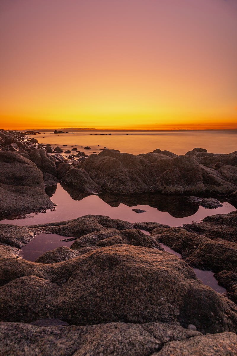 rocky shore during sunset with orange sky, HD phone wallpaper