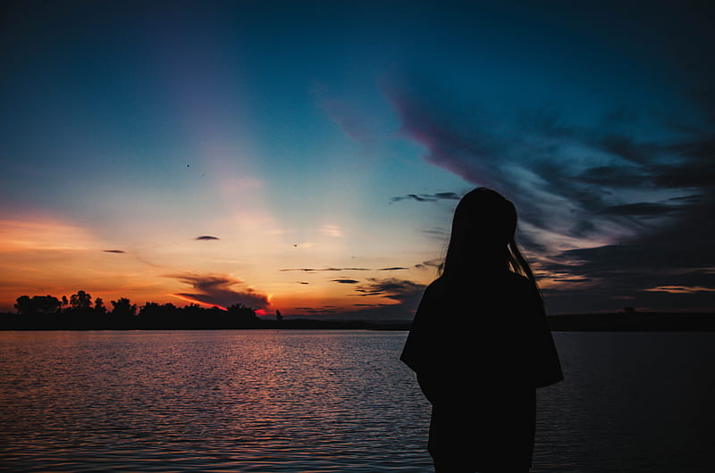 Silhouette of woman standing near body of water during sunset, HD ...