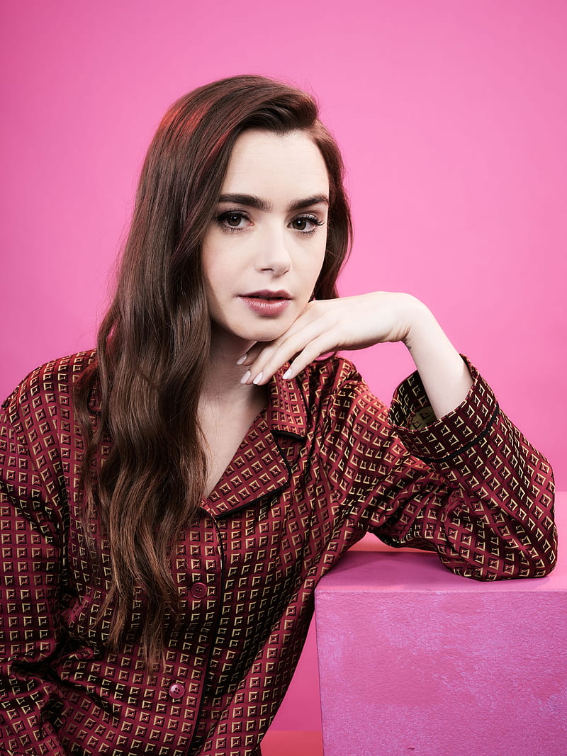 Lily Collins, women, model, actress, brunette, long hair, dark hair, pink background, simple background, sitting, red clothing, face, HD phone wallpaper