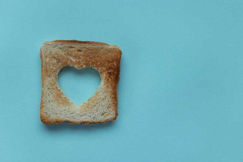 Top view of piece of white bread with cut heart on blue background, HD wallpaper