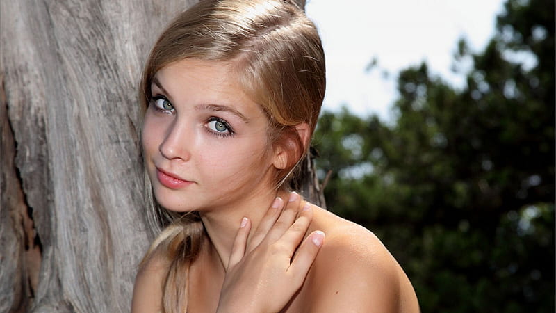 Ash Eyes Girl Model Is Leaning On Tree Trunk Standing In Blur Green