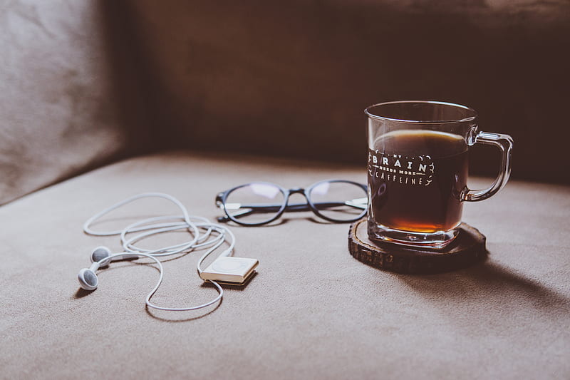 clear Brain printed glass mug on brown wood slab coaster beside black framed eyeglasses and white earphones, HD wallpaper