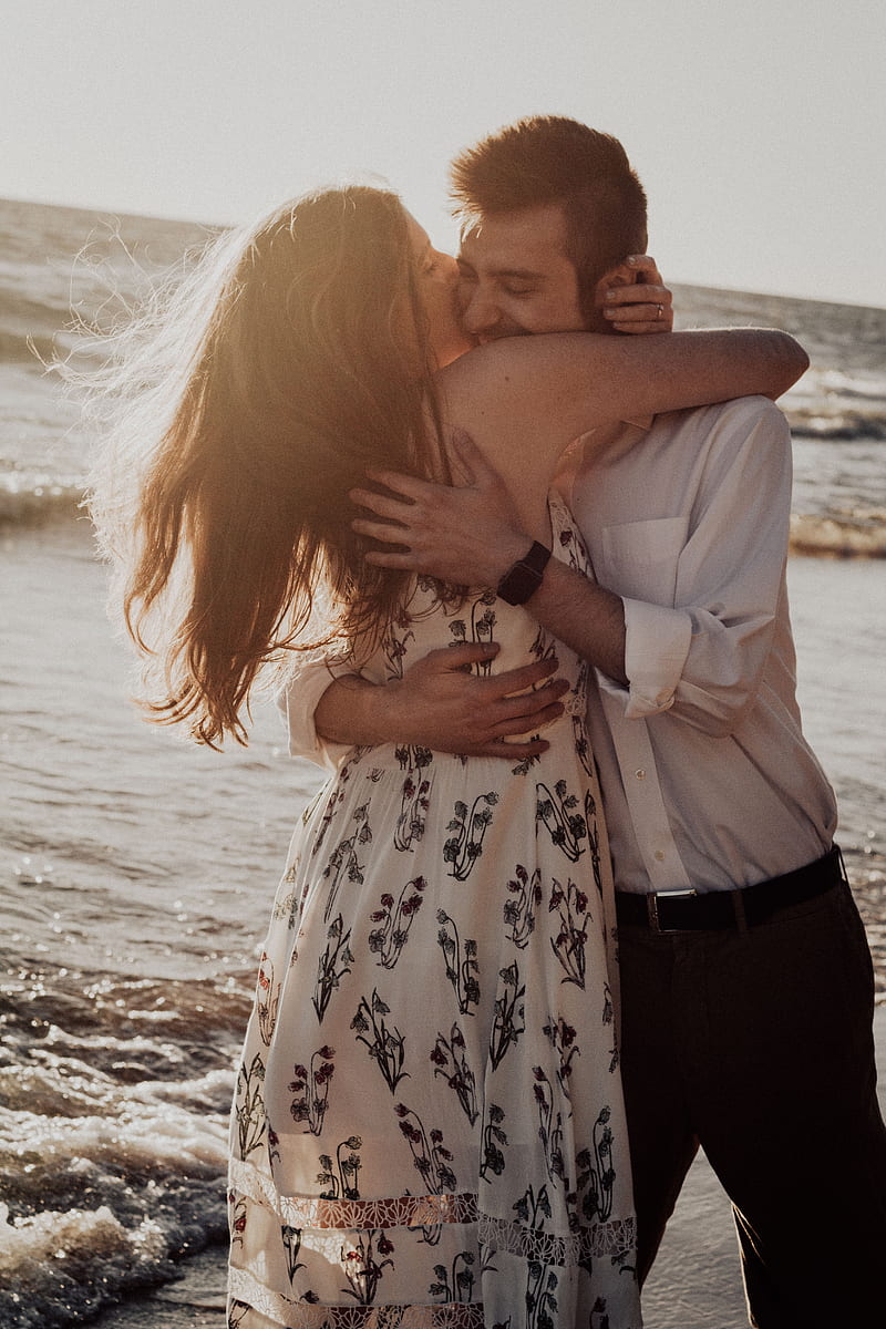 woman hugging and kissing man on cheek on seashore during daytime, HD phone wallpaper