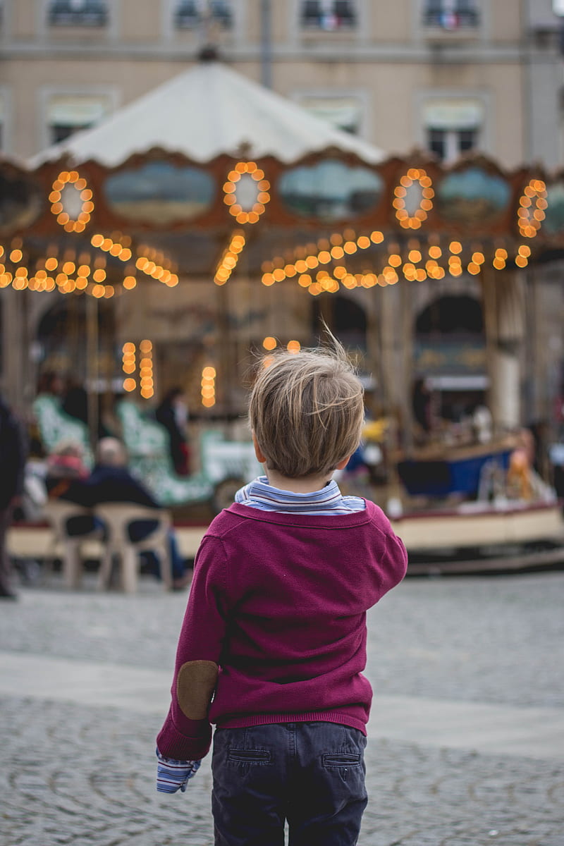 selective focus graphy of boy standing in front of carousel, HD phone wallpaper