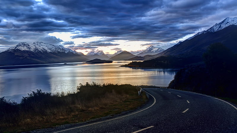 blacktop road down to a lake at sundown, blacktop, sundown, mountains, road, clouds, lake, HD wallpaper
