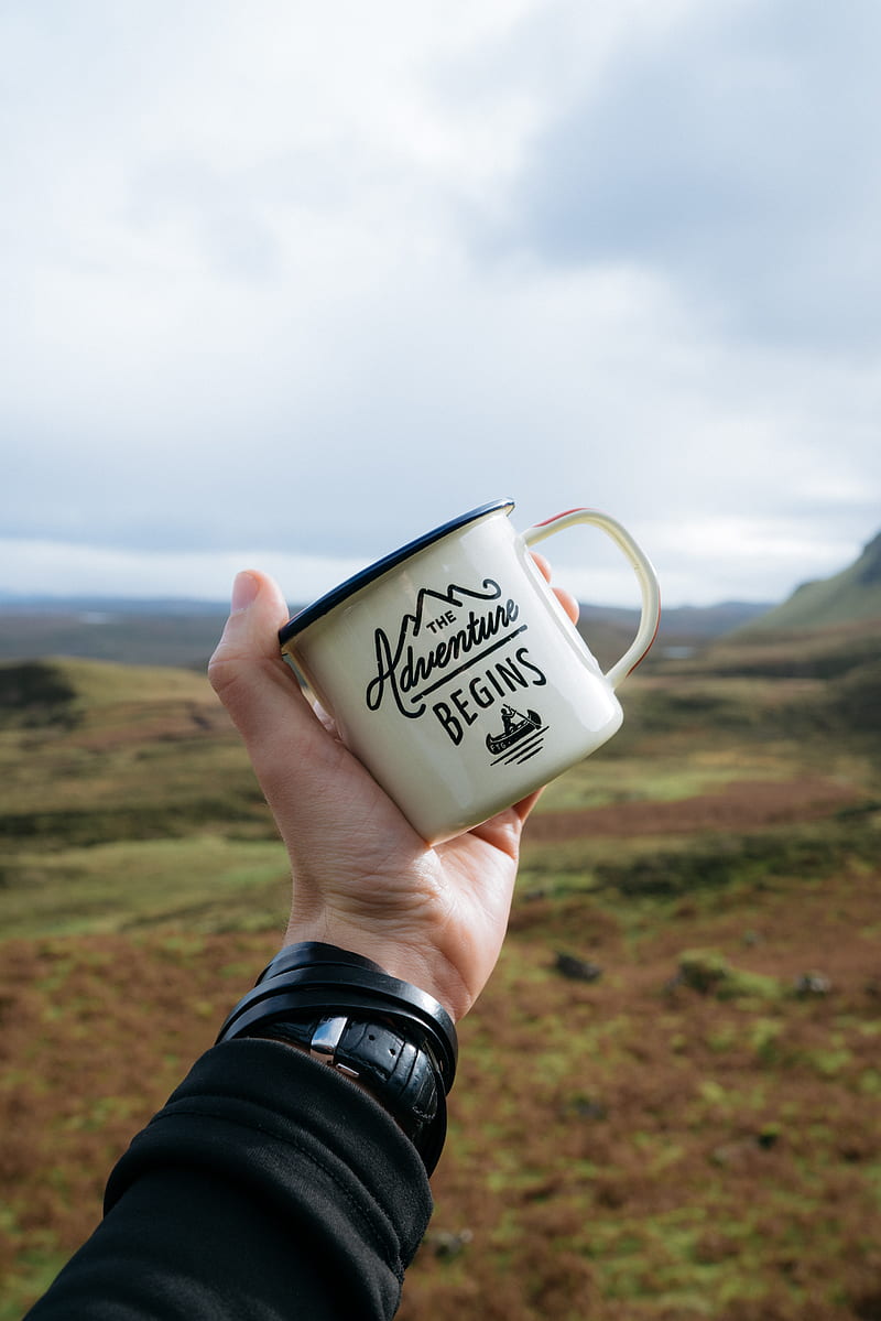 person holding beige and black The Adventure Begins-printed mug during daytime, HD phone wallpaper