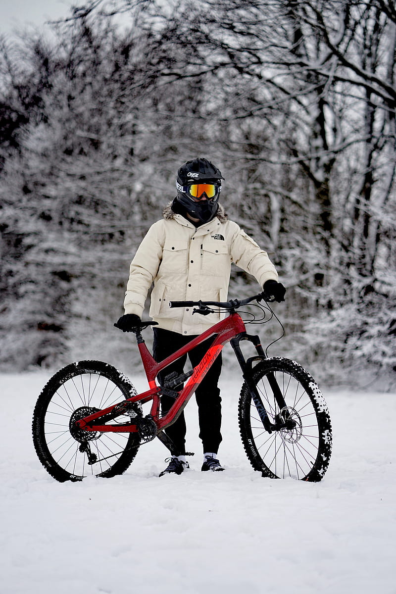 person in brown jacket riding red mountain bike on snow covered ground during daytime, HD phone wallpaper