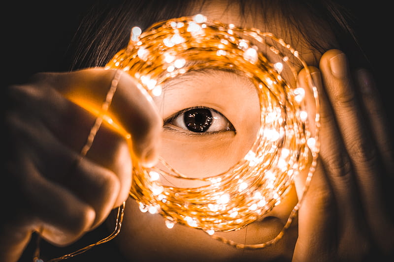 person covering one eye while holding yellow string lights, HD wallpaper