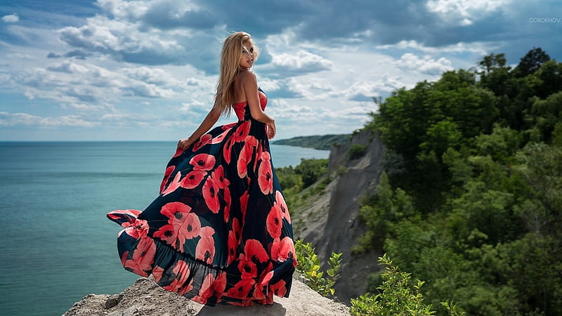Blonde model in Striking Dress, cliff face, Blonde, oean, Long flowing Dress, red and pink poppy pattern, trees, overlook, HD wallpaper