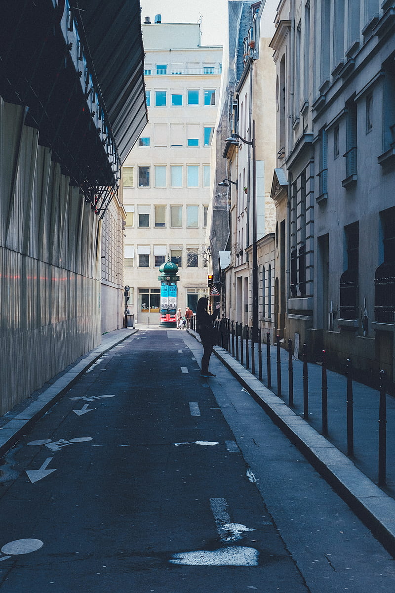 person standing at the side of the road between buildings, HD phone wallpaper