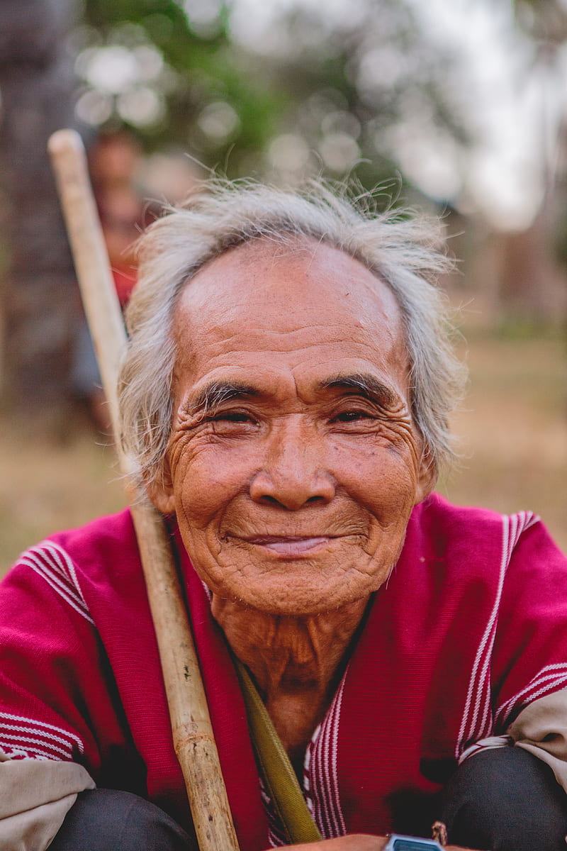 man holding brown stick smiling, HD phone wallpaper