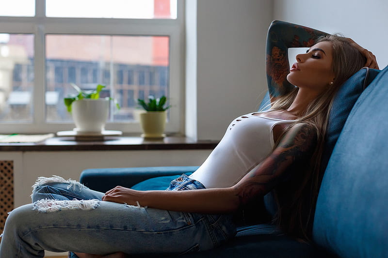 Carmella Rose by the window in torn jeans and black bra