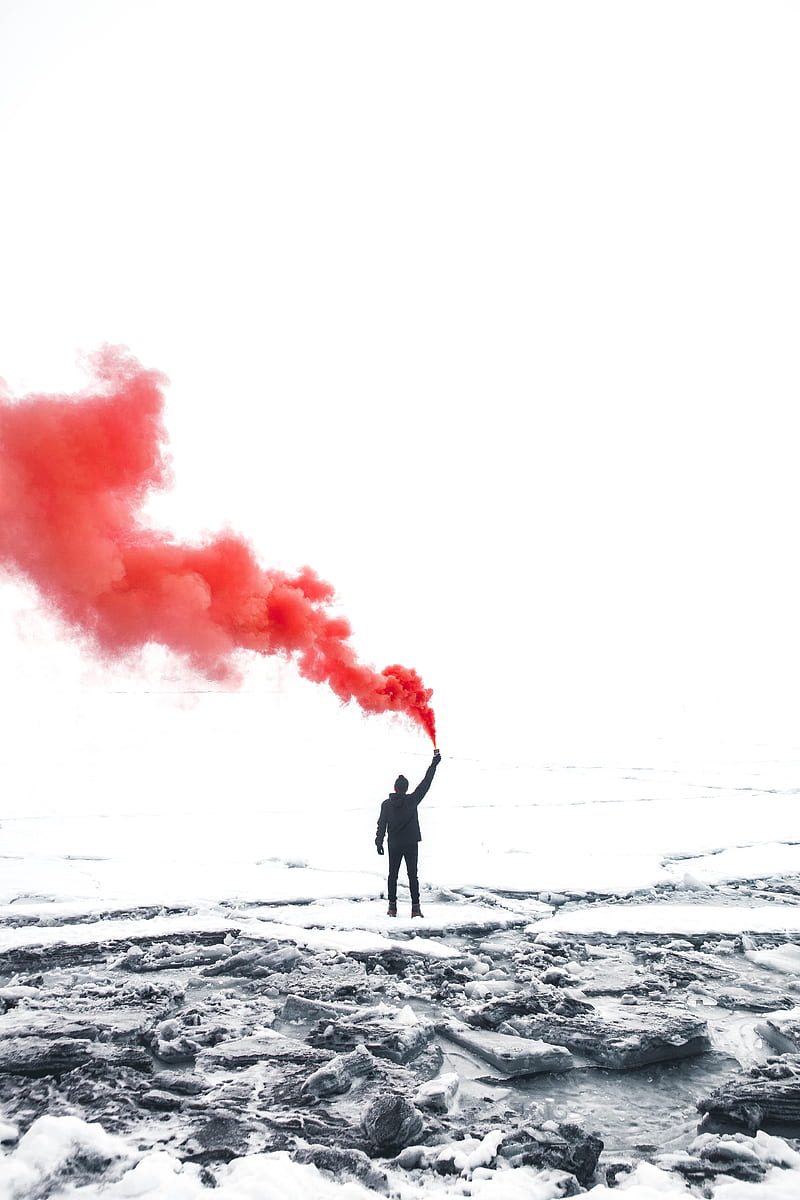 selective color graphy of person holding orange gas smoke standing on snow, HD phone wallpaper