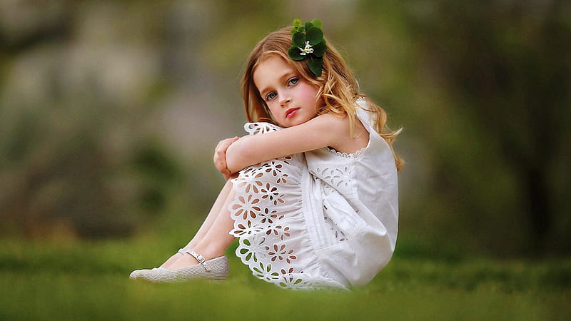 Cute Girl Baby Is Wearing White Dress Sitting On Grass Facing One Side And Having Green Leaves On Head In A Blur Background Cute, HD wallpaper