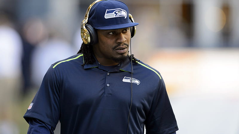 Marshawn Lynch Is Wearing Blue Sports Dress And Cap With Headset Seattle Seahawks, HD wallpaper