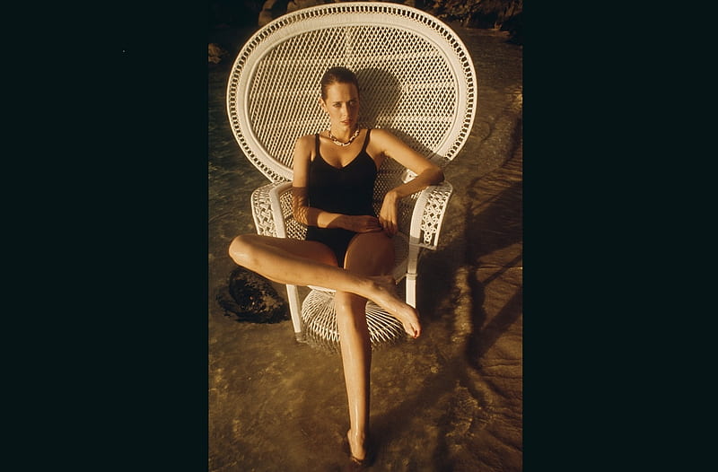 Sylvia Kristel, on the beach, sitting in ratan chair, brunette, one piece black suit, water, HD wallpaper