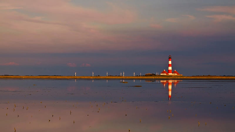 Beautiful red and white lighthouse reflected, windmills, sea