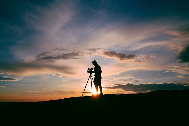 silhouette of man standing beside camera tripod during sunset, HD wallpaper