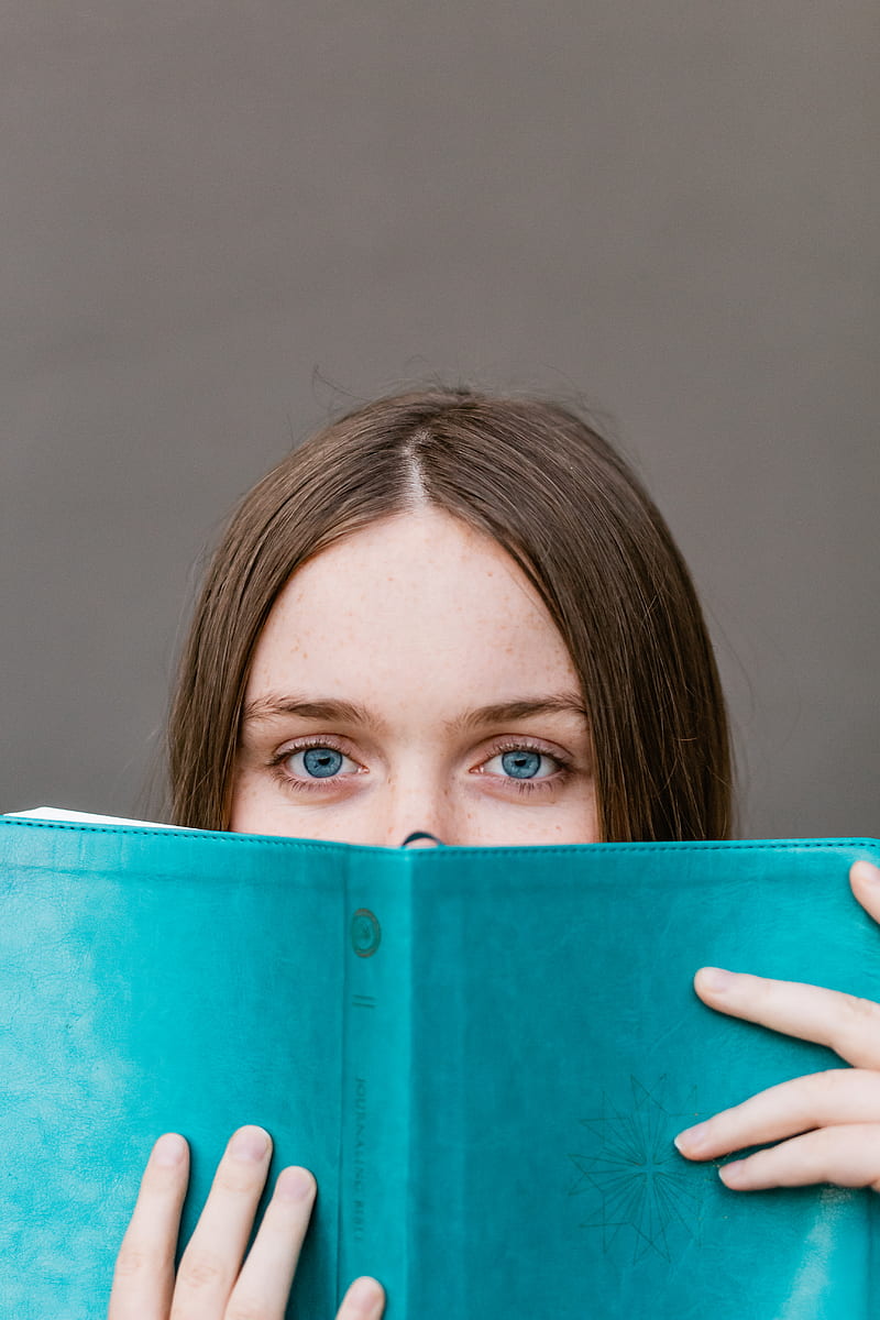 woman covering her face with teal book, HD phone wallpaper