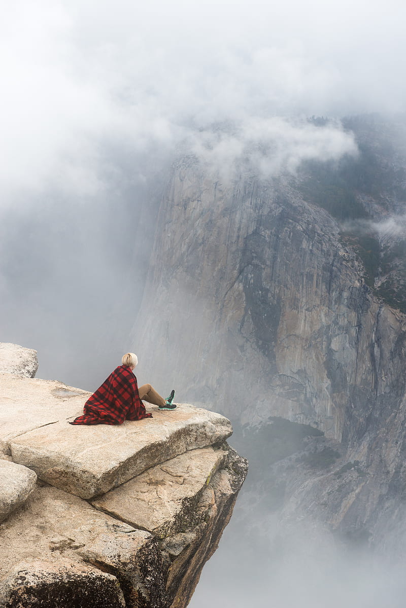 person sitting on cliff under cumulus cloud, HD phone wallpaper