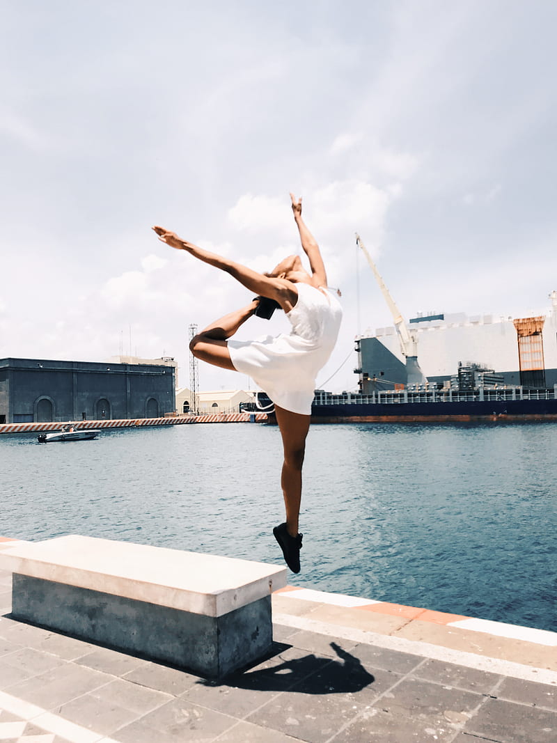 woman jumping in mid-air near body of water during daytime, HD phone wallpaper