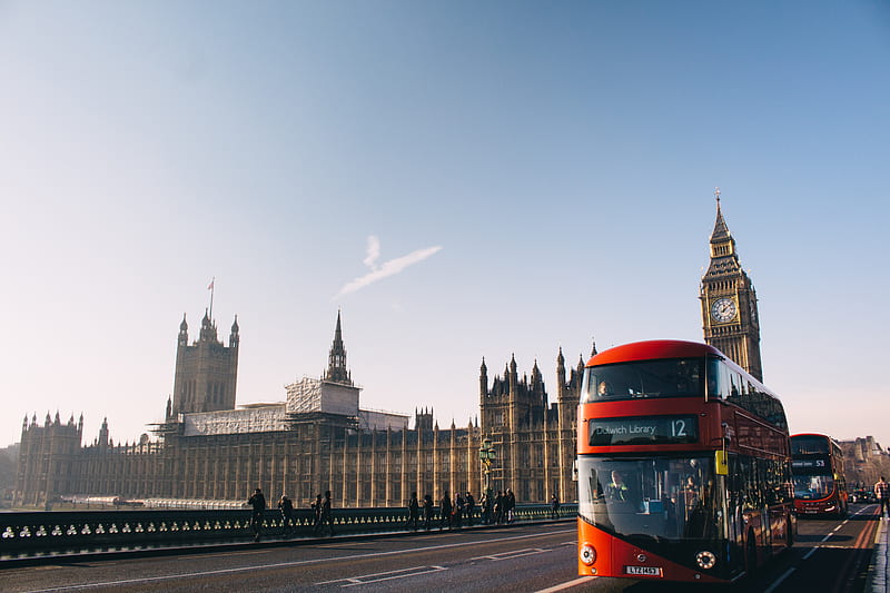 red double-decker bus passing Palace of Westminster, London during daytime, HD wallpaper