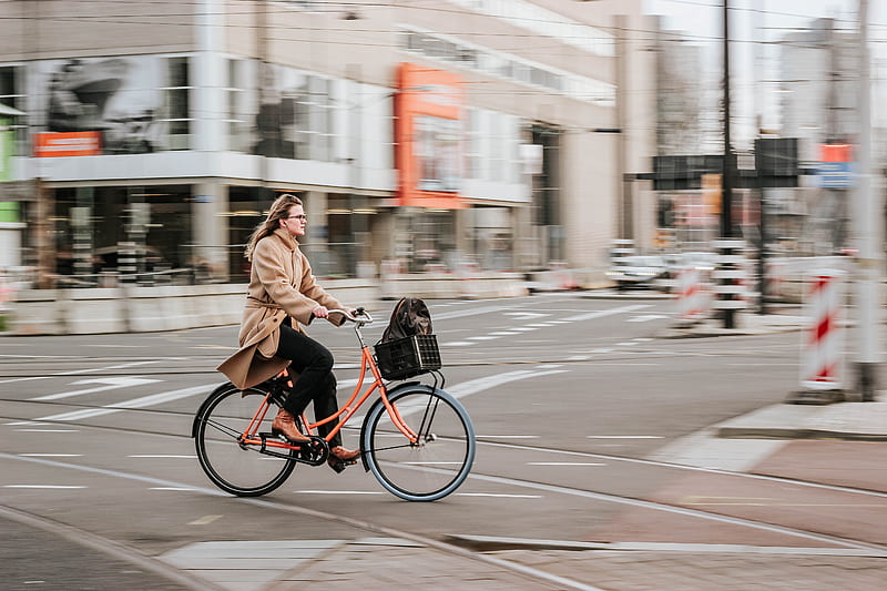 woman in brown coat riding on black bicycle on road during daytime, HD wallpaper