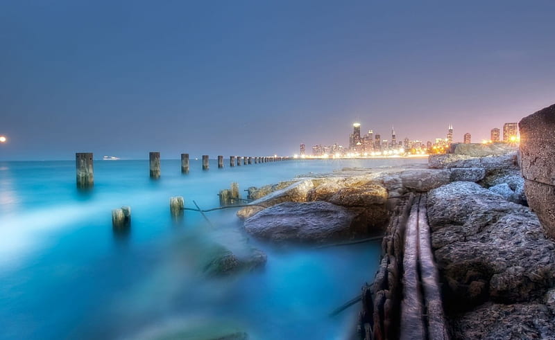 Night in a blur, rocks, distance, sea, lights, beach, city, boat, evening,  blue, HD wallpaper | Peakpx