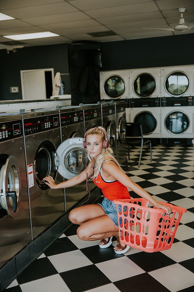 woman kneeling in front of front-load clothes washer inside laundry shop, HD phone wallpaper