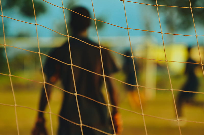 man in black T-shirt through soccer goal post, HD wallpaper
