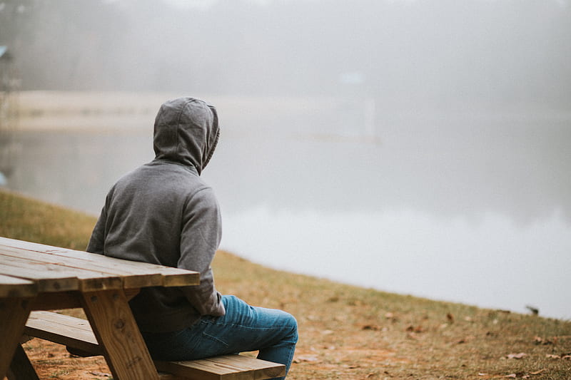 person in gray hoodie sitting on picnic table staring at the fog during daytime, HD wallpaper