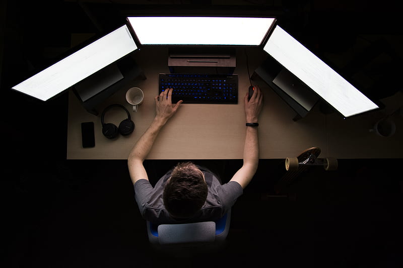 man facing three computer monitors while sitting, HD wallpaper