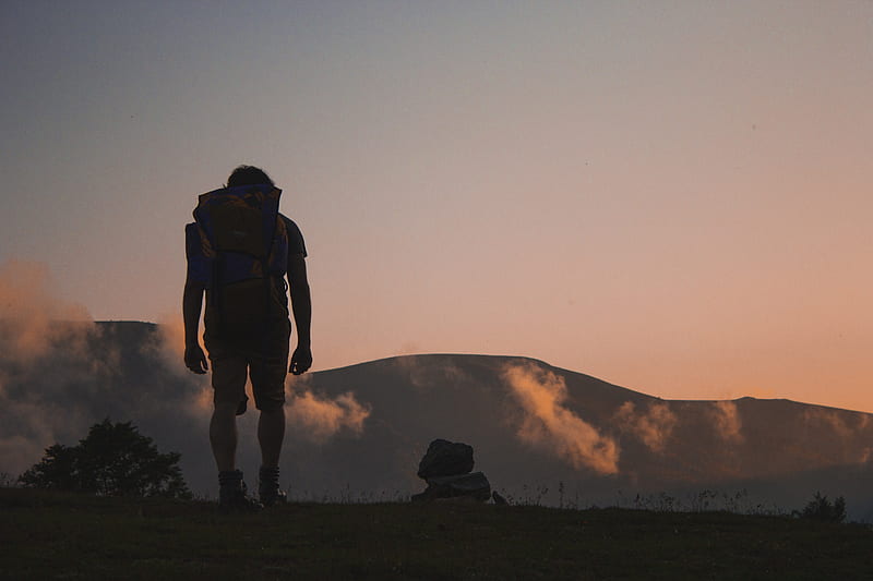 silhouette of man walking along field leading to mountain, HD wallpaper