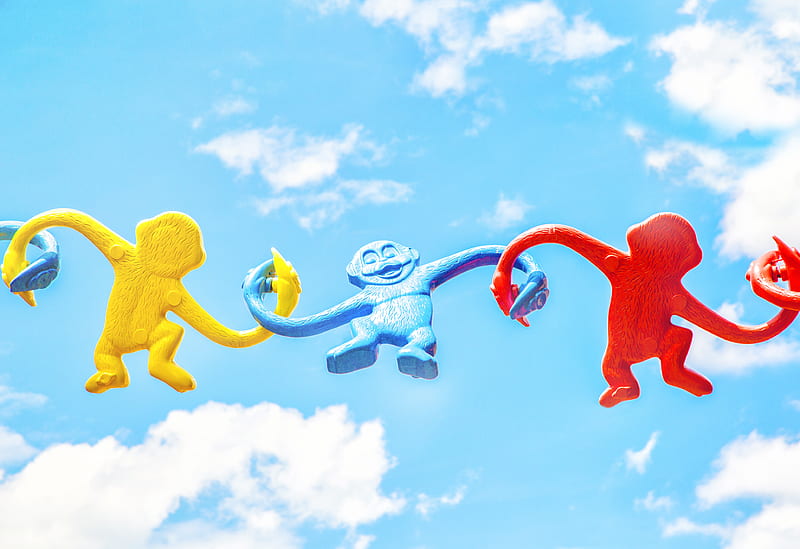 three assorted-color monkey plastic toys holding each other during daytime, HD wallpaper